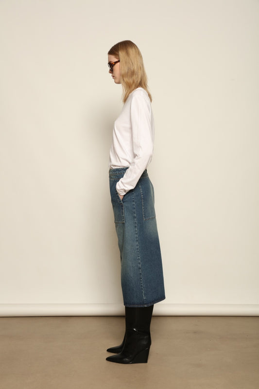 Model is wearing Le Bermuda 4 Poches by Happy Haus, organic denim mid-length bermuda shorts with four oversized patch pockets, curated in the House of Woven Stories selection.