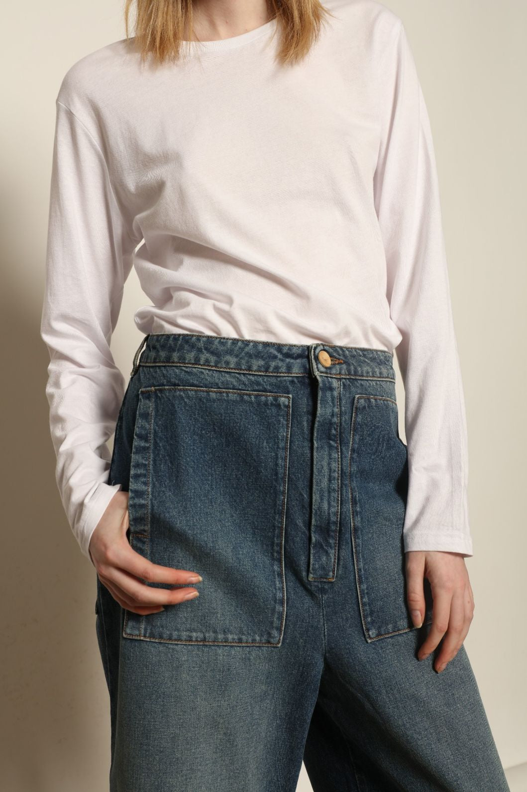 Model is wearing Le Bermuda 4 Poches by Happy Haus, organic denim mid-length bermuda shorts with four oversized patch pockets, curated in the House of Woven Stories selection.