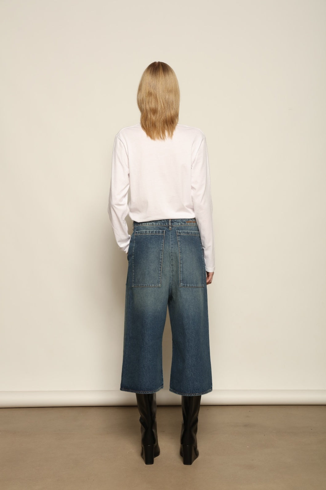 Model is wearing Le Bermuda 4 Poches by Happy Haus, organic denim mid-length bermuda shorts with four oversized patch pockets, curated in the House of Woven Stories selection.