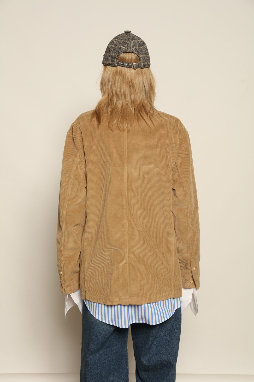 Model is wearing Le Blazer in Vintage Beige by Happy Haus, a GOTS-certified Italian corduroy cotton tailored jacket with relaxed straight silhouette, flap pockets, wooden buttons and soft back slit, curated in the House of Woven Stories selection.