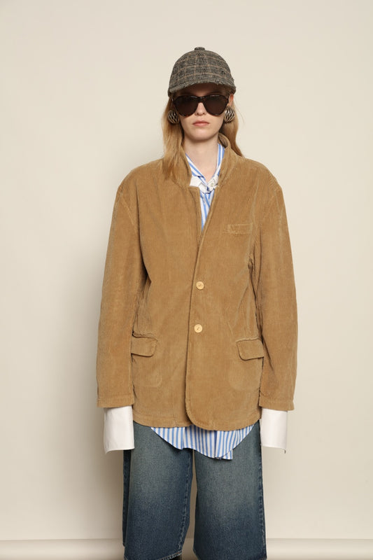 Model is wearing Le Blazer in Vintage Beige by Happy Haus, a GOTS-certified Italian corduroy cotton tailored jacket with relaxed straight silhouette, flap pockets, wooden buttons and soft back slit, curated in the House of Woven Stories selection.