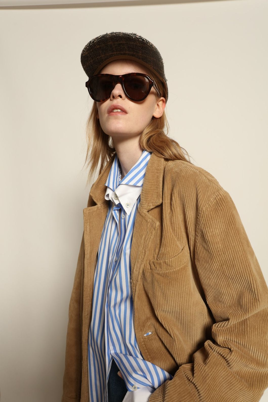 Model is wearing Le Blazer in Vintage Beige by Happy Haus, a GOTS-certified Italian corduroy cotton tailored jacket with relaxed straight silhouette, flap pockets, wooden buttons and soft back slit, curated in the House of Woven Stories selection.