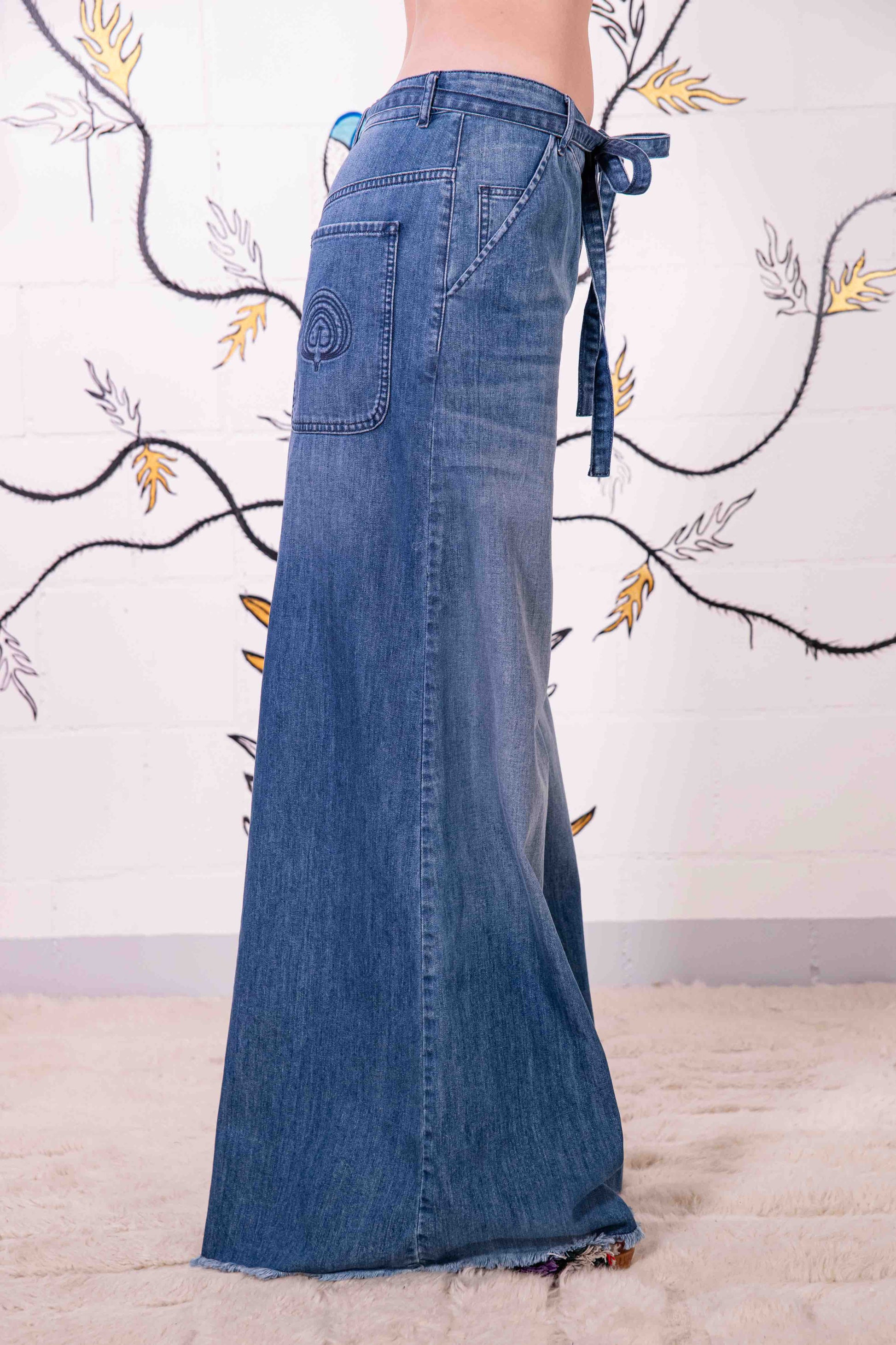Model is wearing relaxed, flared-fit jeans by Happy Haus, crafted in Italy from 100% DETOX-certified cotton. A sustainable essential from the House of Woven Stories collection, designed for timeless, conscious style.