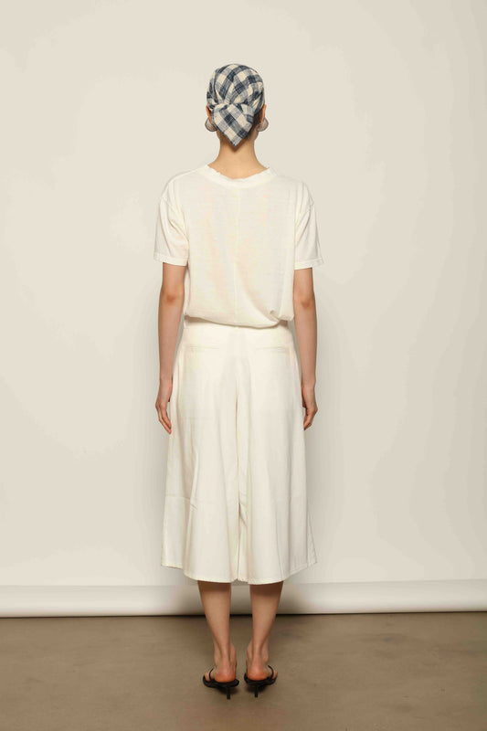 Model wearing the La Jupe Culotte in Blanc Cassè by Happy Haus from the House of Nomad Stories collection, featuring premium Japanese denim, a high-waisted fit, wide-leg silhouette, and elegant ankle-length design.