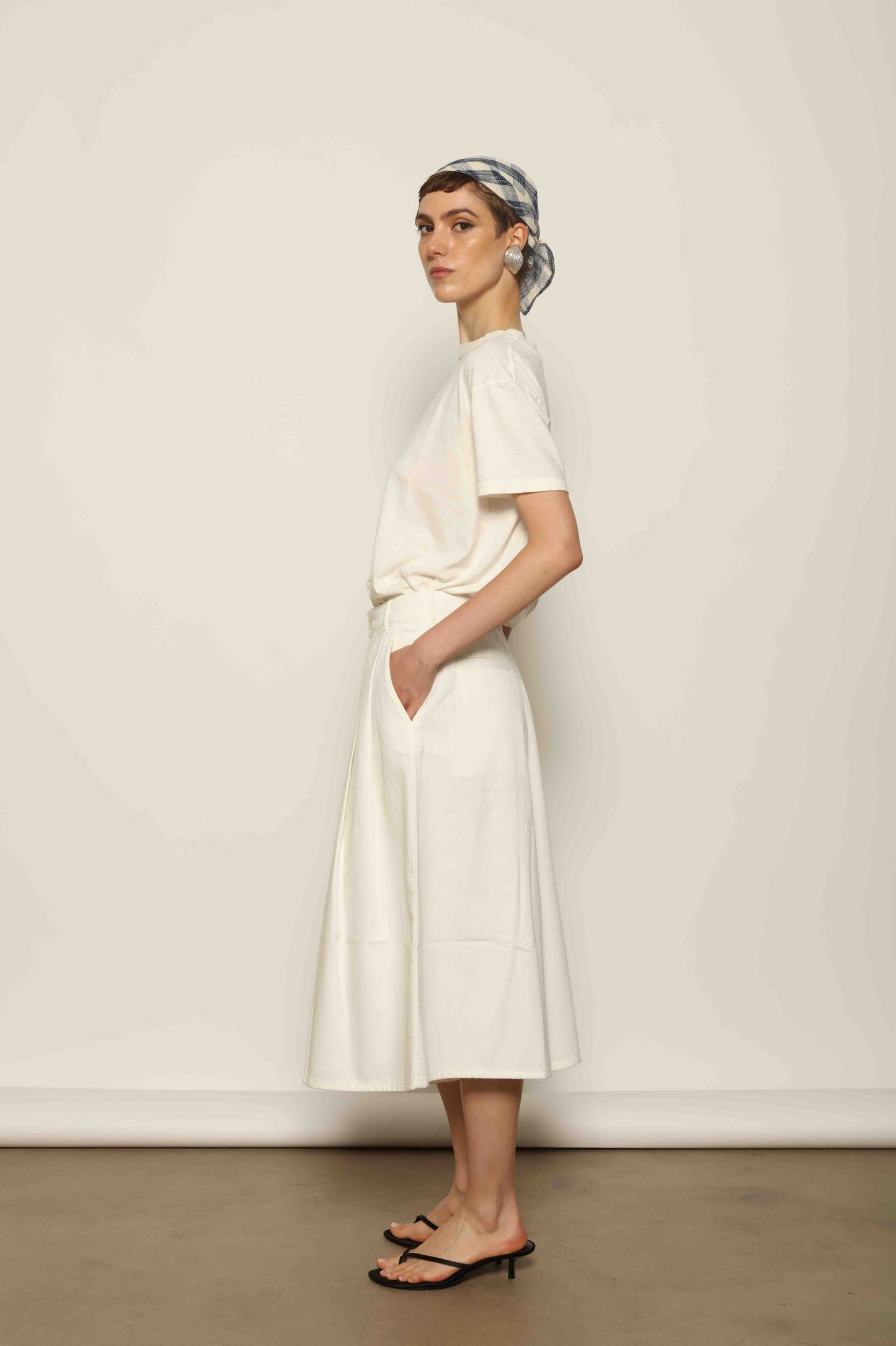 Model wearing the La Jupe Culotte in Blanc Cassè by Happy Haus from the House of Nomad Stories collection, featuring premium Japanese denim, a high-waisted fit, wide-leg silhouette, and elegant ankle-length design.