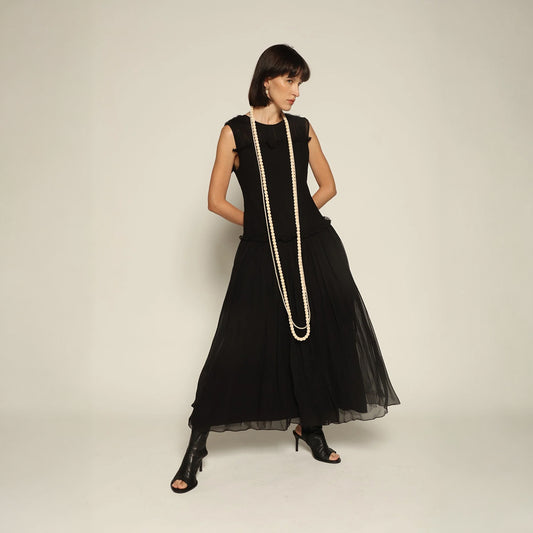 Model wearing a black silk Sera Dress by Abadia from the House of Nomad Stories collection, featuring a fitted bodice and fluid midi skirt with an elegant lightweight drape.