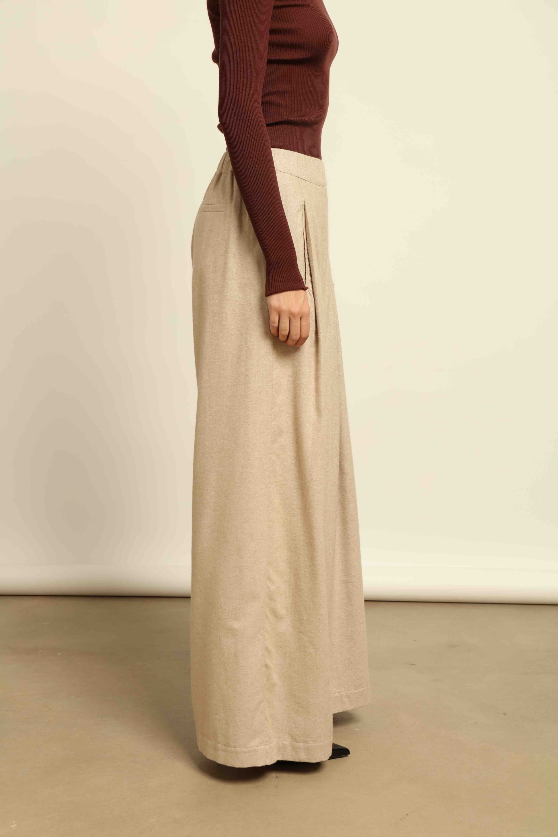 Model is wearing House of Woven Stories camel sweatpants, handmade in Italy with a relaxed fit and elasticated waist, crafted in sustainable luxury.