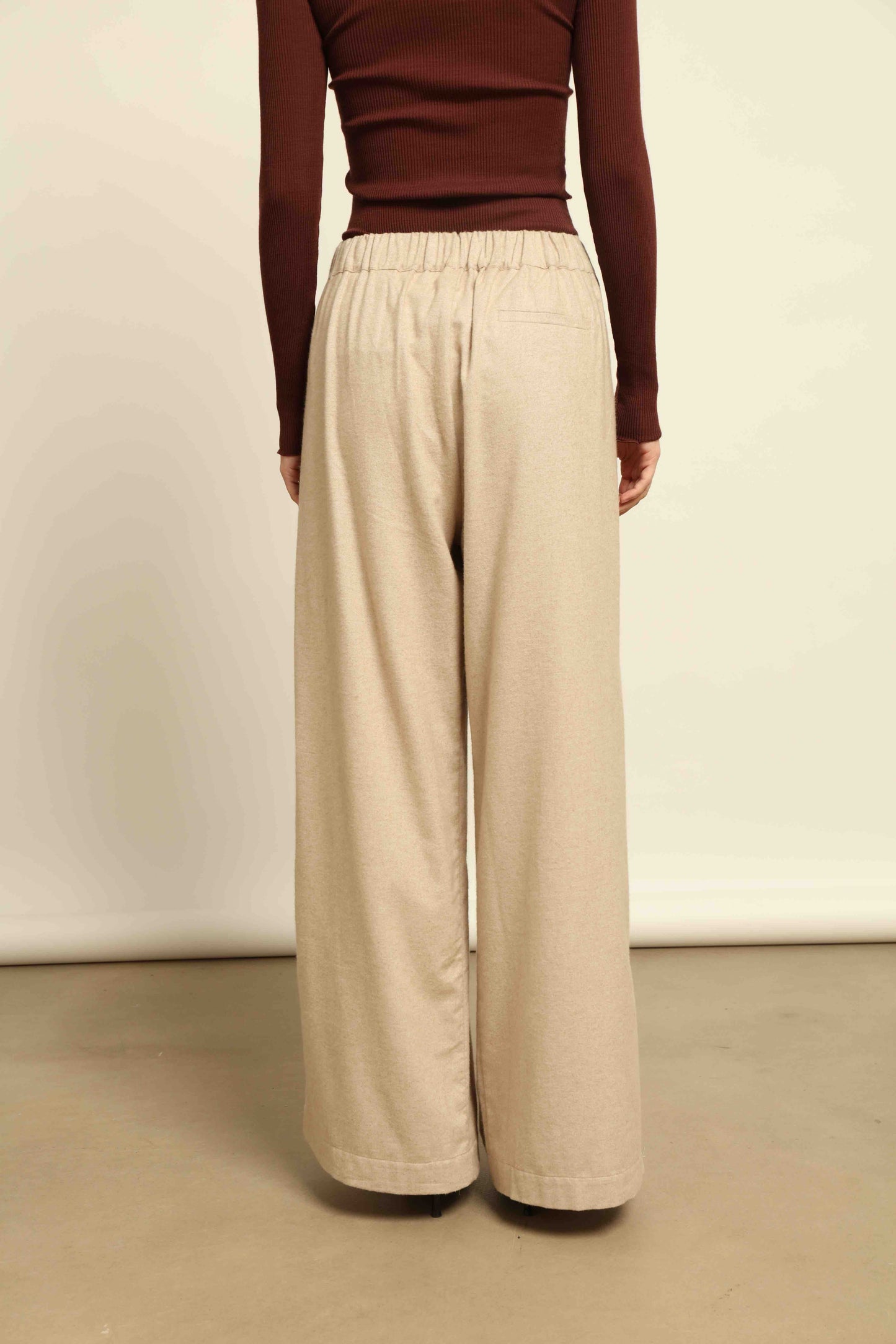 Model is wearing House of Woven Stories camel sweatpants, handmade in Italy with a relaxed fit and elasticated waist, crafted in sustainable luxury.