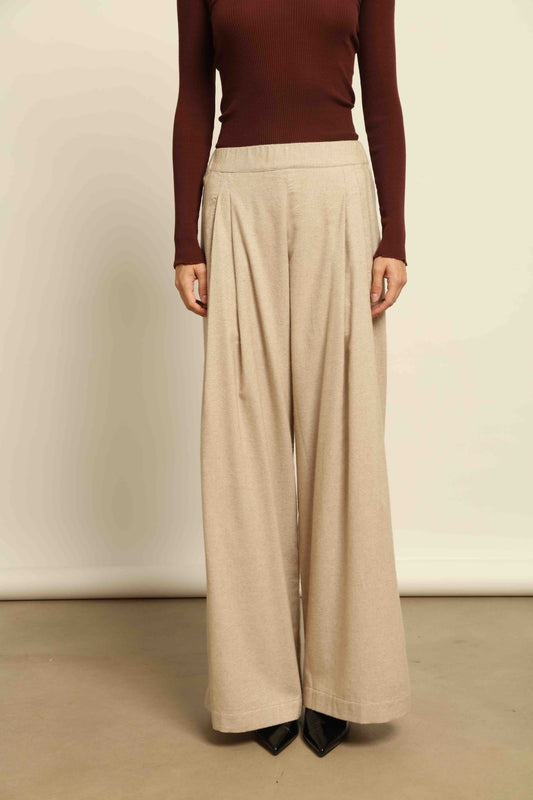 Model is wearing House of Woven Stories camel sweatpants, handmade in Italy with a relaxed fit and elasticated waist, crafted in sustainable luxury.