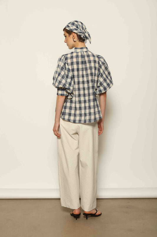 Model wearing the White Brigitta Organic Cotton Trousers by House of Woven Stories, featuring a relaxed fit, lightweight organic cotton fabric, and a timeless minimalist silhouette made in Italy.
