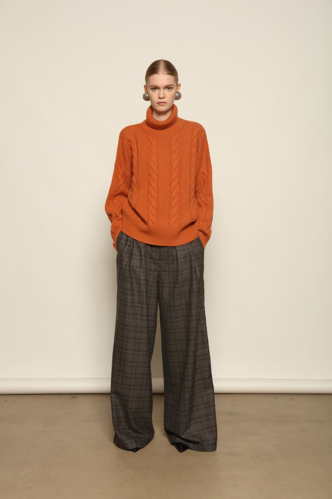 Model is wearing the Brown Check Parigi Pants by House of Woven Stories, relaxed straight-leg Merino wool trousers with a soft brown check pattern, handcrafted in Italy.