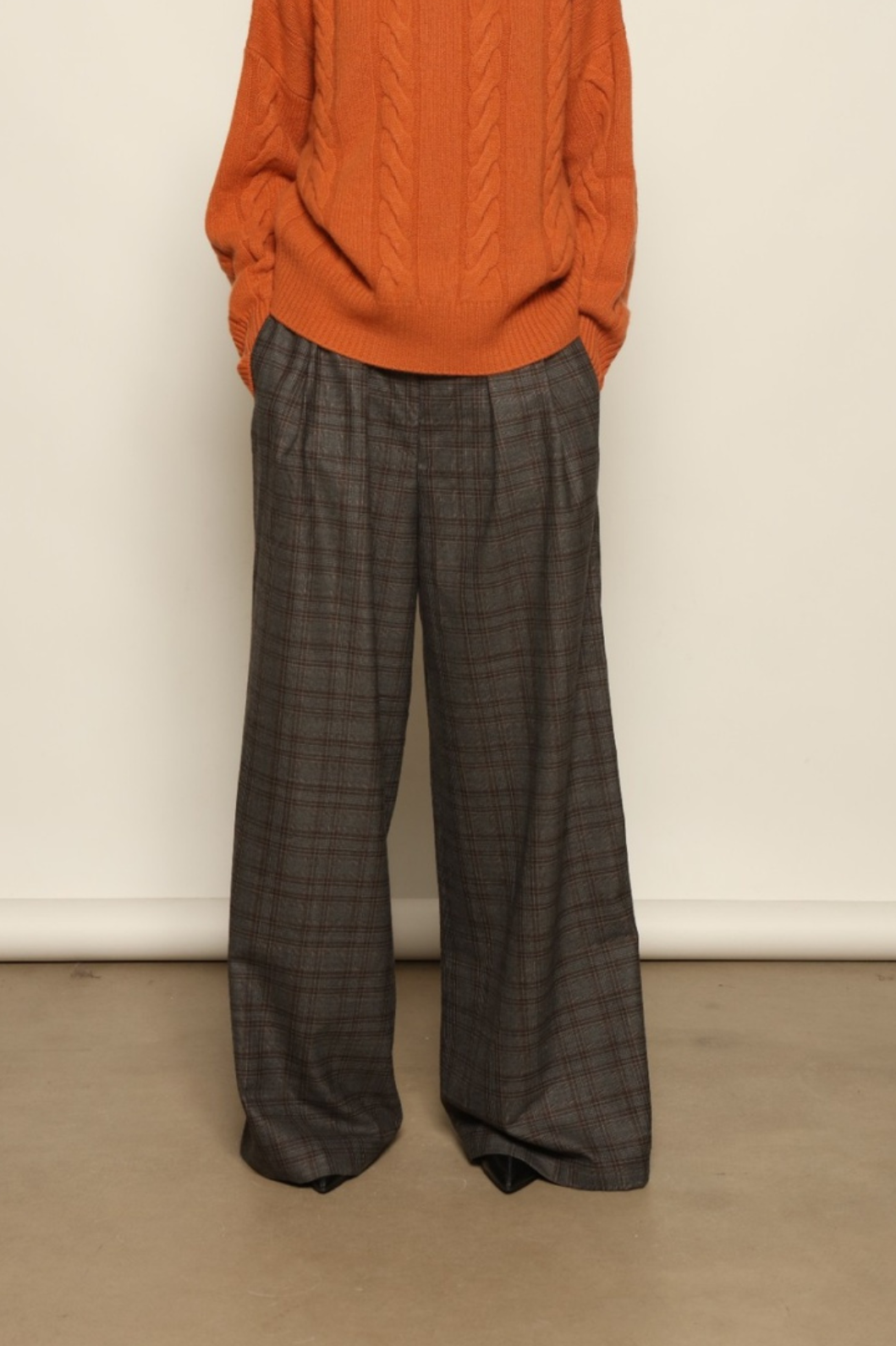 Model is wearing the Brown Check Parigi Pants by House of Woven Stories, relaxed straight-leg Merino wool trousers with a soft brown check pattern, handcrafted in Italy.