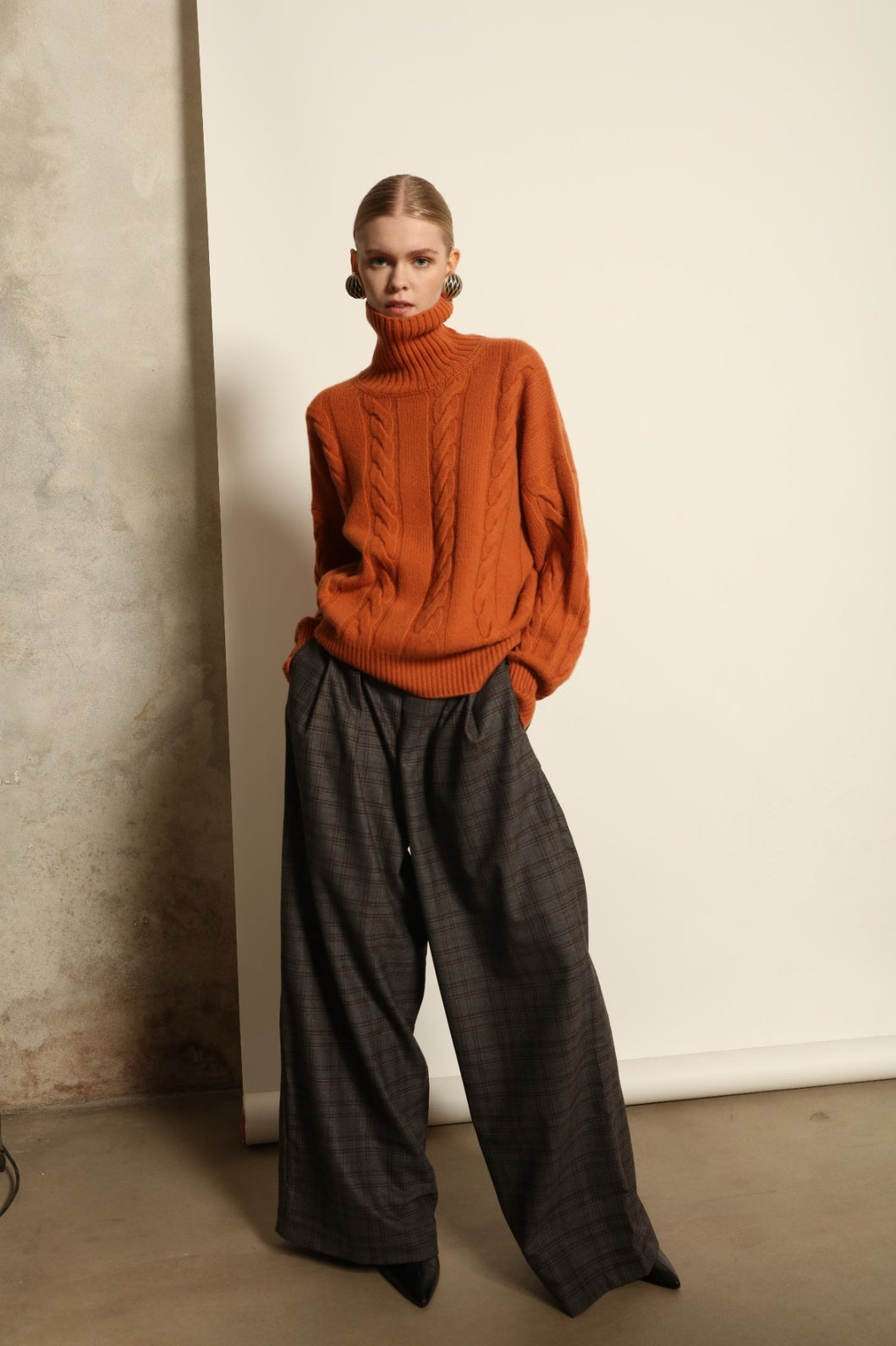 Model is wearing the Brown Check Parigi Pants by House of Woven Stories, relaxed straight-leg Merino wool trousers with a soft brown check pattern, handcrafted in Italy.