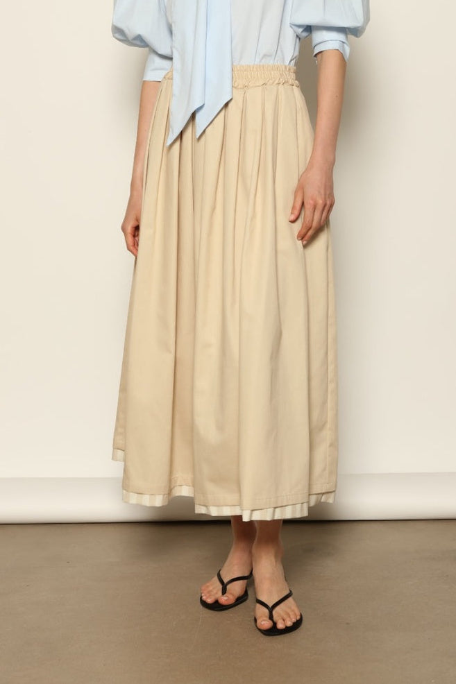 Model wearing the Seoul Camel Skirt by House of Woven Stories, featuring a structured camel-toned fabric, high-waisted fit, and a clean tailored silhouette with defined architectural lines.