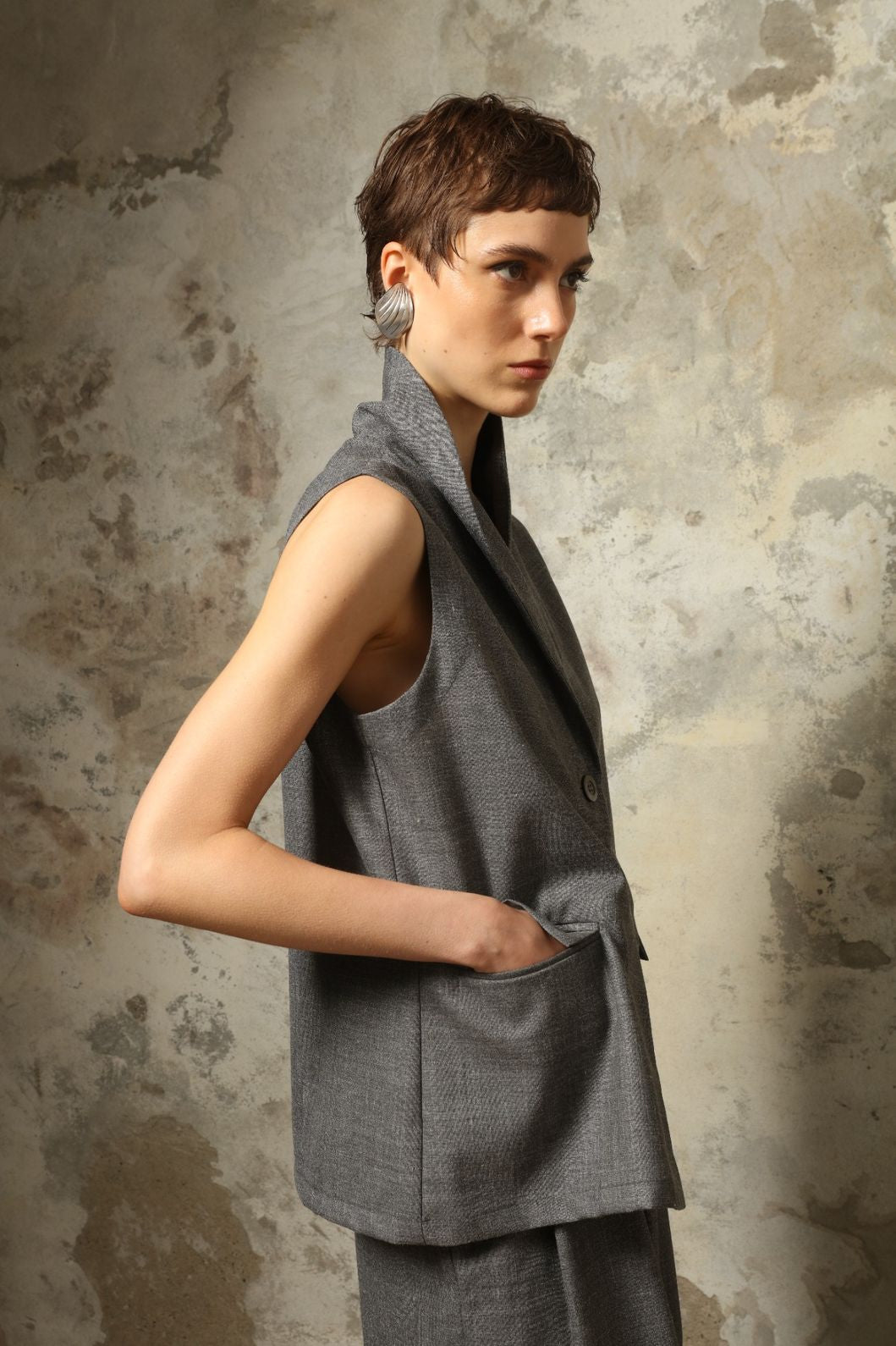 Model wearing the Franca Grey Off White Gilet by House of Woven Stories, featuring a tailored structured silhouette, clean minimalist design, and refined layered styling in a grey off-white tone.