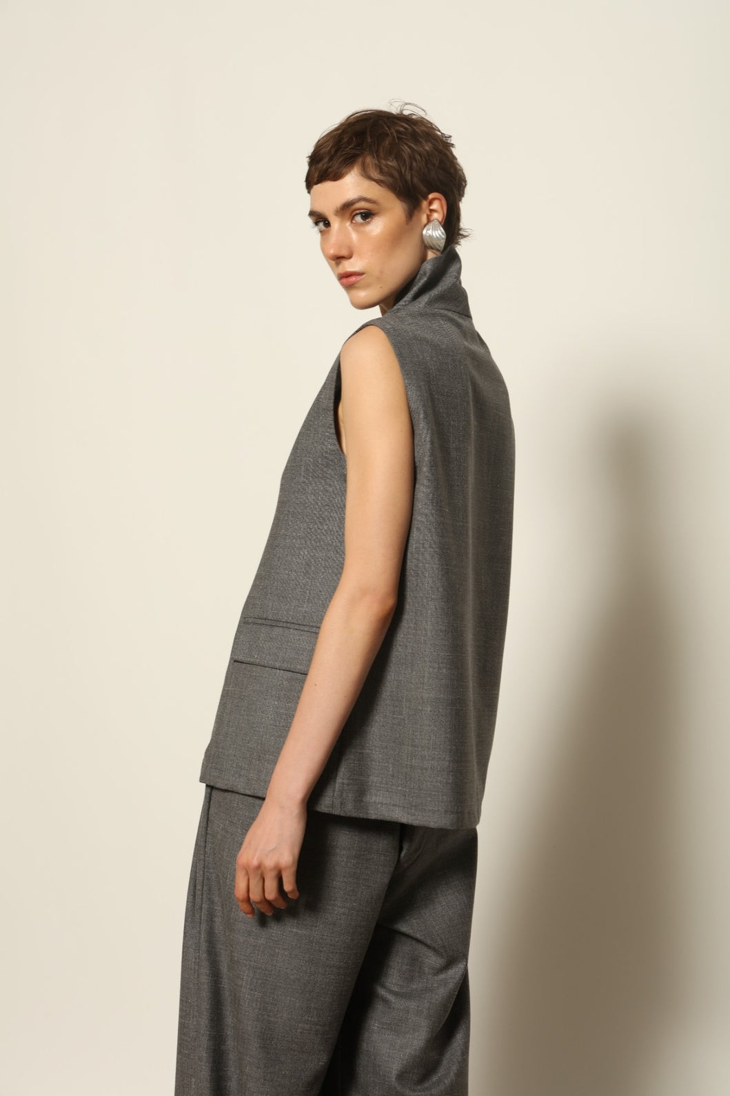 Model wearing the Franca Grey Off White Gilet by House of Woven Stories, featuring a tailored structured silhouette, clean minimalist design, and refined layered styling in a grey off-white tone.