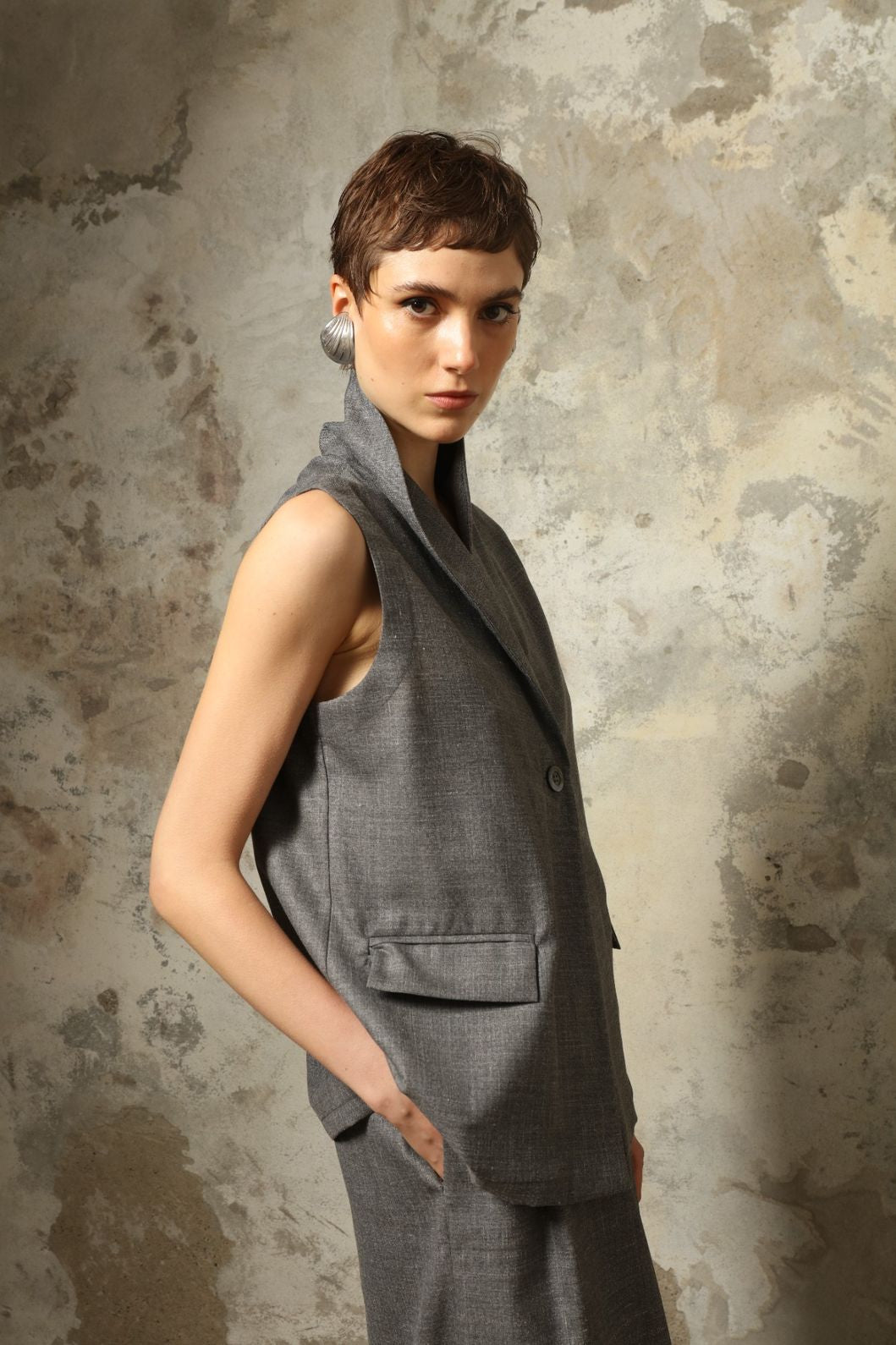Model wearing the Franca Grey Off White Gilet by House of Woven Stories, featuring a tailored structured silhouette, clean minimalist design, and refined layered styling in a grey off-white tone.