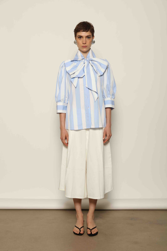 Model wearing the Karin Blue and White Macro Striped Blouse by House of Woven Stories, featuring bold macro stripes, relaxed fit silhouette, and lightweight 100% organic cotton fabric made in Italy.