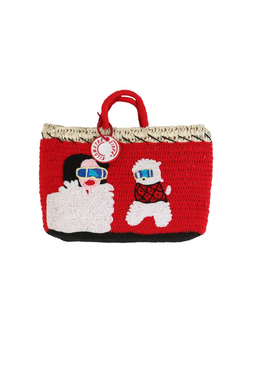 Eleonora & Bijou Undercover basket bag by Kilometre Paris, curated by House of Woven Stories, featuring red crochet with embroidered winter figures and dog motif on handwoven straw, inspired by Gstaad, travel, and playful craftsmanship