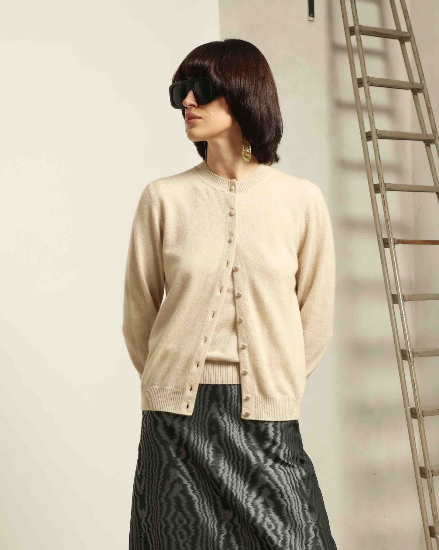 Model is wearing House of Woven Stories Natural Natascha Pullover, round neck, short sleeves, relaxed fit, made from 100% pure cashmere sourced from Inner Mongolia and Tibet, handmade in Italy.