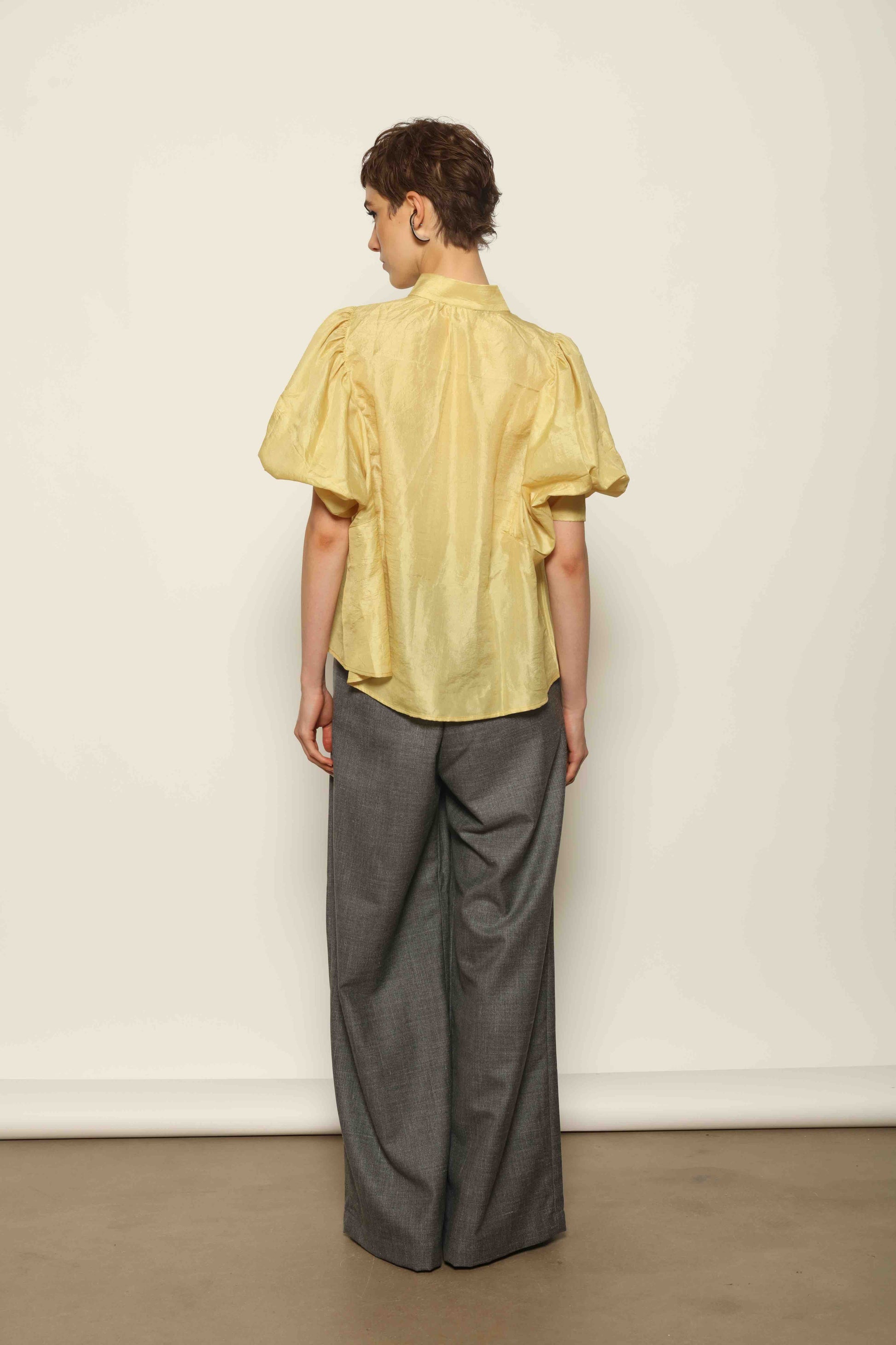 Model wearing the Lola Yellow Blouse by House of Woven Stories, crafted from naturally dyed Mulberry silk with a Mandarin collar, button-front closure, and short balloon sleeves with fitted cuffs.