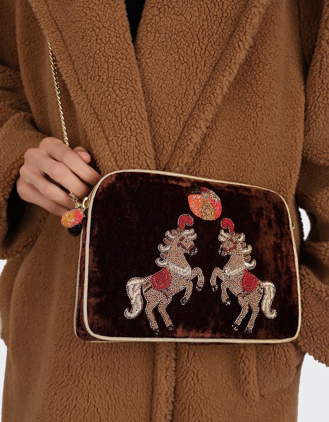 Olivia Dar Horse Brown Velvet Sling Bag by House of Woven Stories, featuring two rearing horses hand-embroidered with beads and threads in red, gold and white, with a removable chain strap for shoulder or crossbody wear.