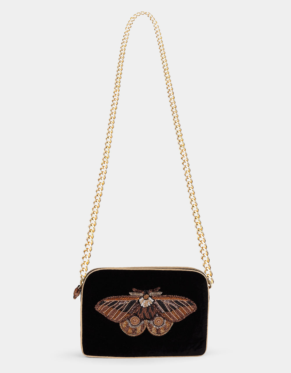 Olivia Dar Nebelia Black Velvet Sling Bag by House of Woven Stories, featuring a hand-embroidered moth motif in bronze, gold and silver, embellished with pearls and sequins, and a removable chain strap for shoulder or crossbody wear.
