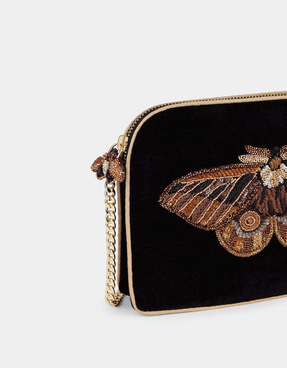 Olivia Dar Nebelia Black Velvet Sling Bag by House of Woven Stories, featuring a hand-embroidered moth motif in bronze, gold and silver, embellished with pearls and sequins, and a removable chain strap for shoulder or crossbody wear.