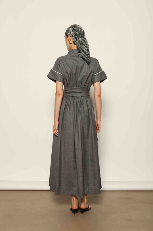 Model wearing the Saint Remy Grey Off White Midi Dress by House of Woven Stories, featuring a wrap silhouette, adjustable belt, half sleeves, and subtle white piping detail in a fluid elegant fabric.