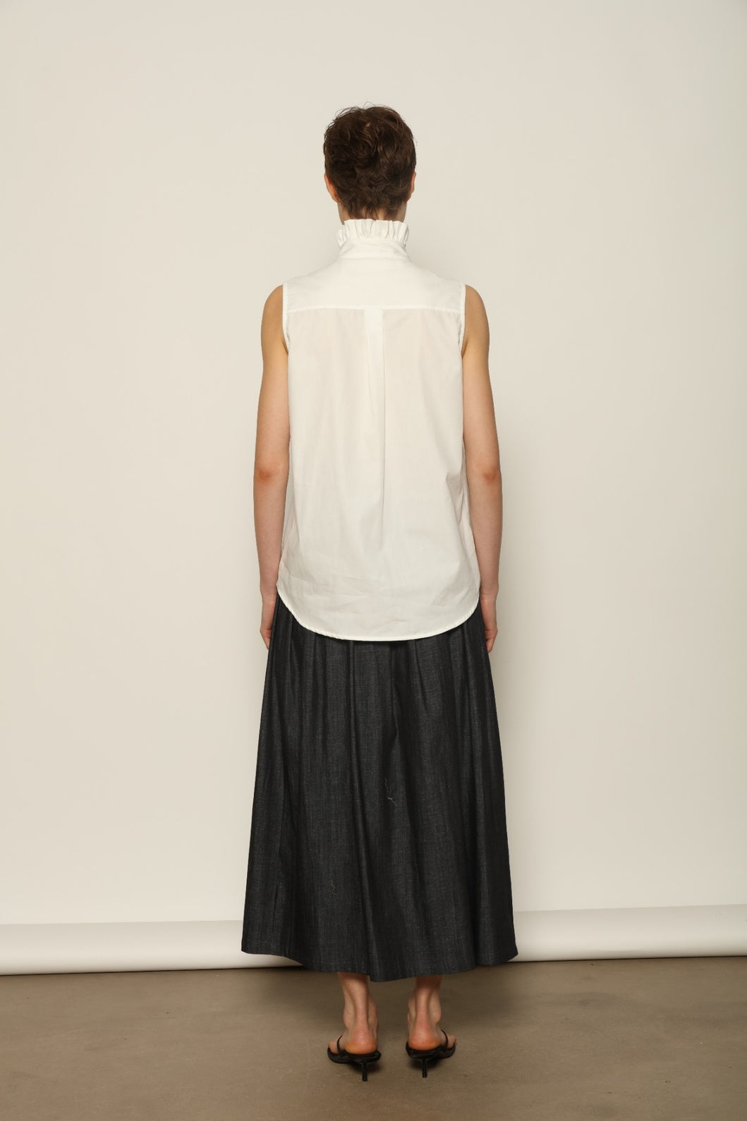 Model wearing the Seoul Ink Denim Skirt by House of Woven Stories, featuring deep indigo denim, a structured silhouette, and refined tailoring for a timeless and elegant look.