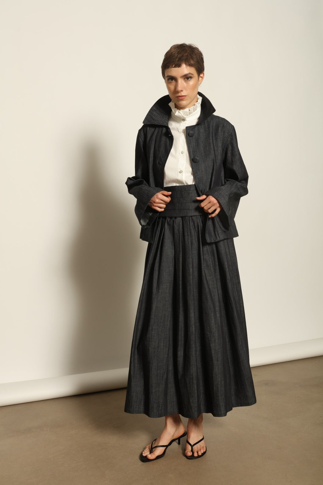 Model wearing the Seoul Ink Denim Skirt by House of Woven Stories, featuring deep indigo denim, a structured silhouette, and refined tailoring for a timeless and elegant look.