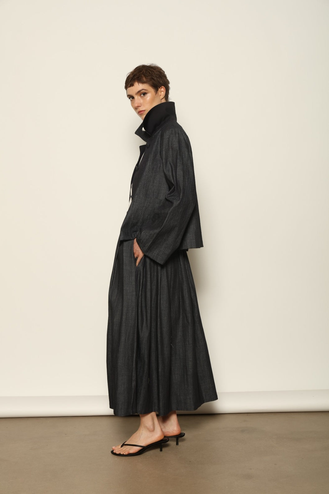 Model wearing the Seoul Ink Denim Skirt by House of Woven Stories, featuring deep indigo denim, a structured silhouette, and refined tailoring for a timeless and elegant look.