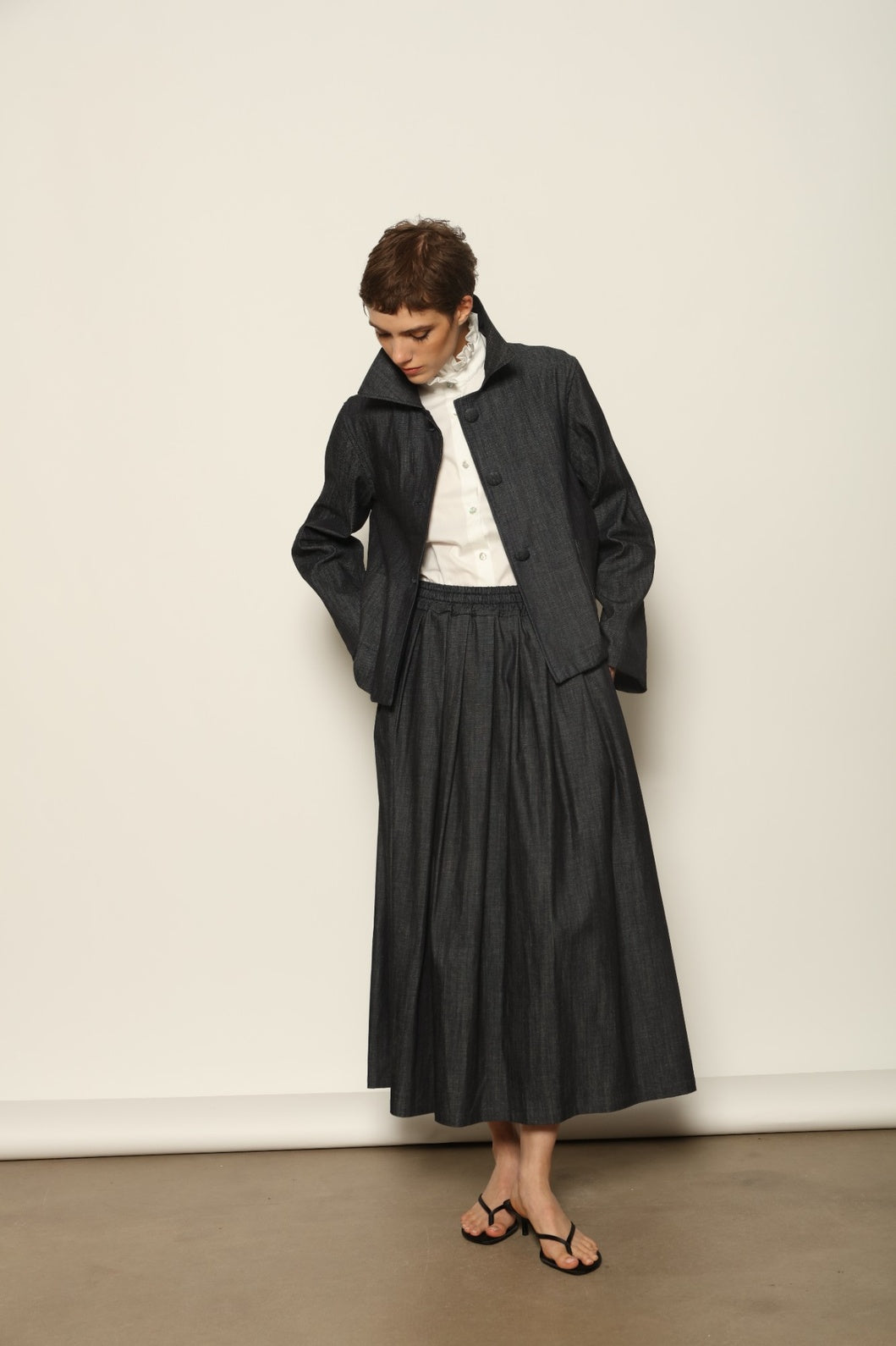 Model wearing the Seoul Ink Denim Skirt by House of Woven Stories, featuring deep indigo denim, a structured silhouette, and refined tailoring for a timeless and elegant look.