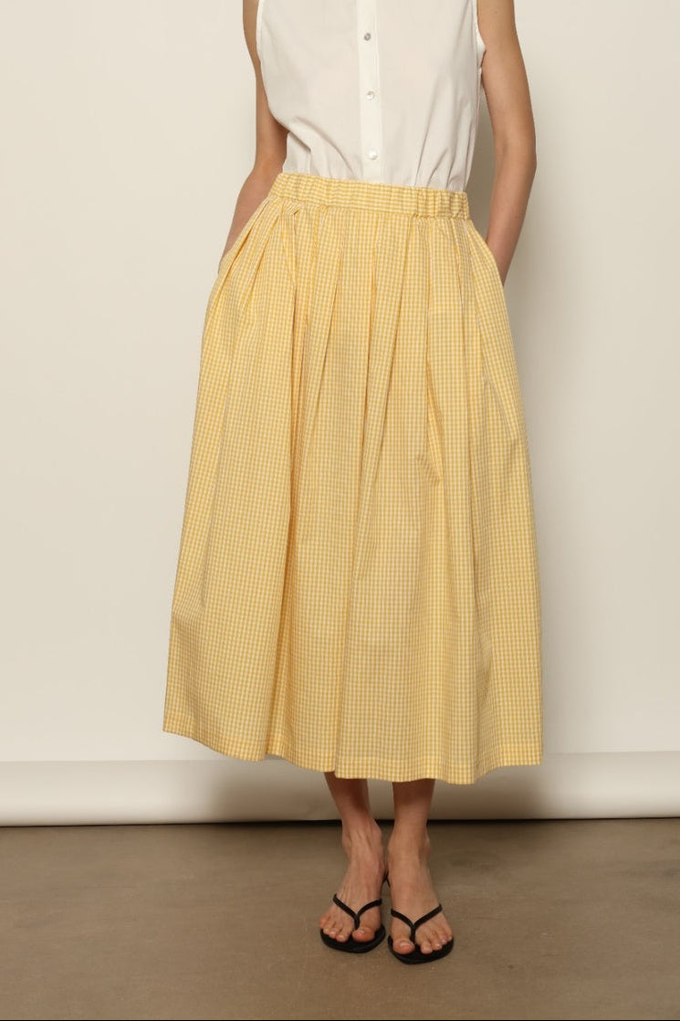 Model wearing the Seoul Vichy Butter Yellow Skirt by House of Woven Stories, featuring a butter yellow gingham pattern, draped silhouette, white piping waistband, and elegant summer design.