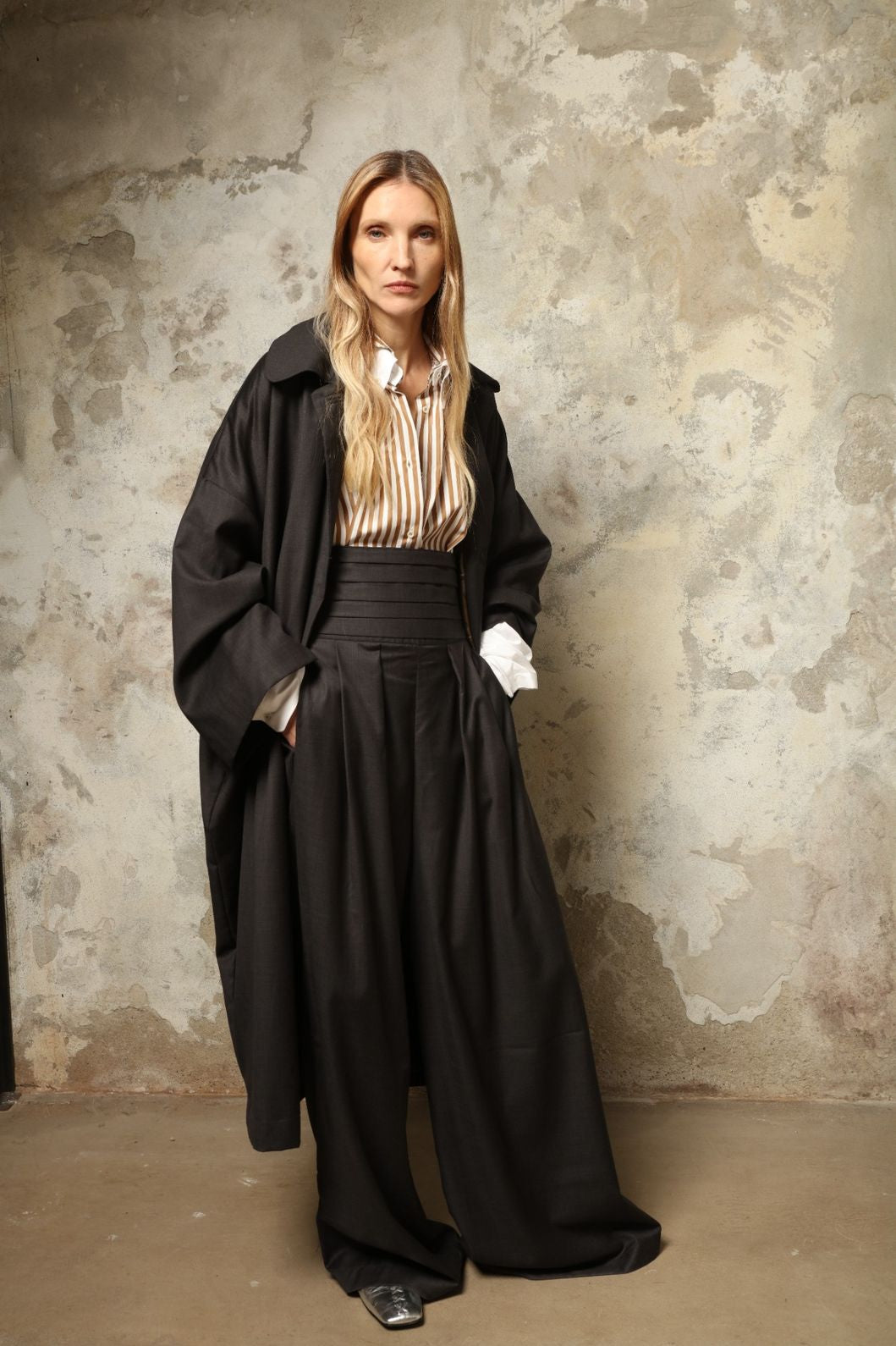 Model is wearing the Sergey Anthracite Cummerbund by House of Woven Stories, a sculptural pleated waist belt in deep anthracite designed to define the silhouette with refined elegance.