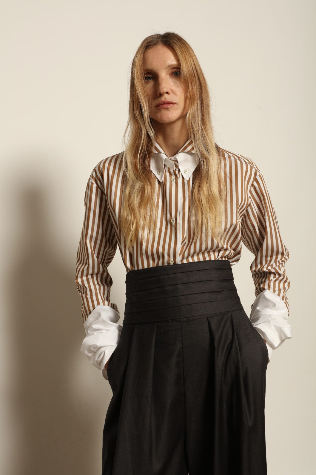 Model is wearing the Sergey Anthracite Cummerbund by House of Woven Stories, a sculptural pleated waist belt in deep anthracite designed to define the silhouette with refined elegance.