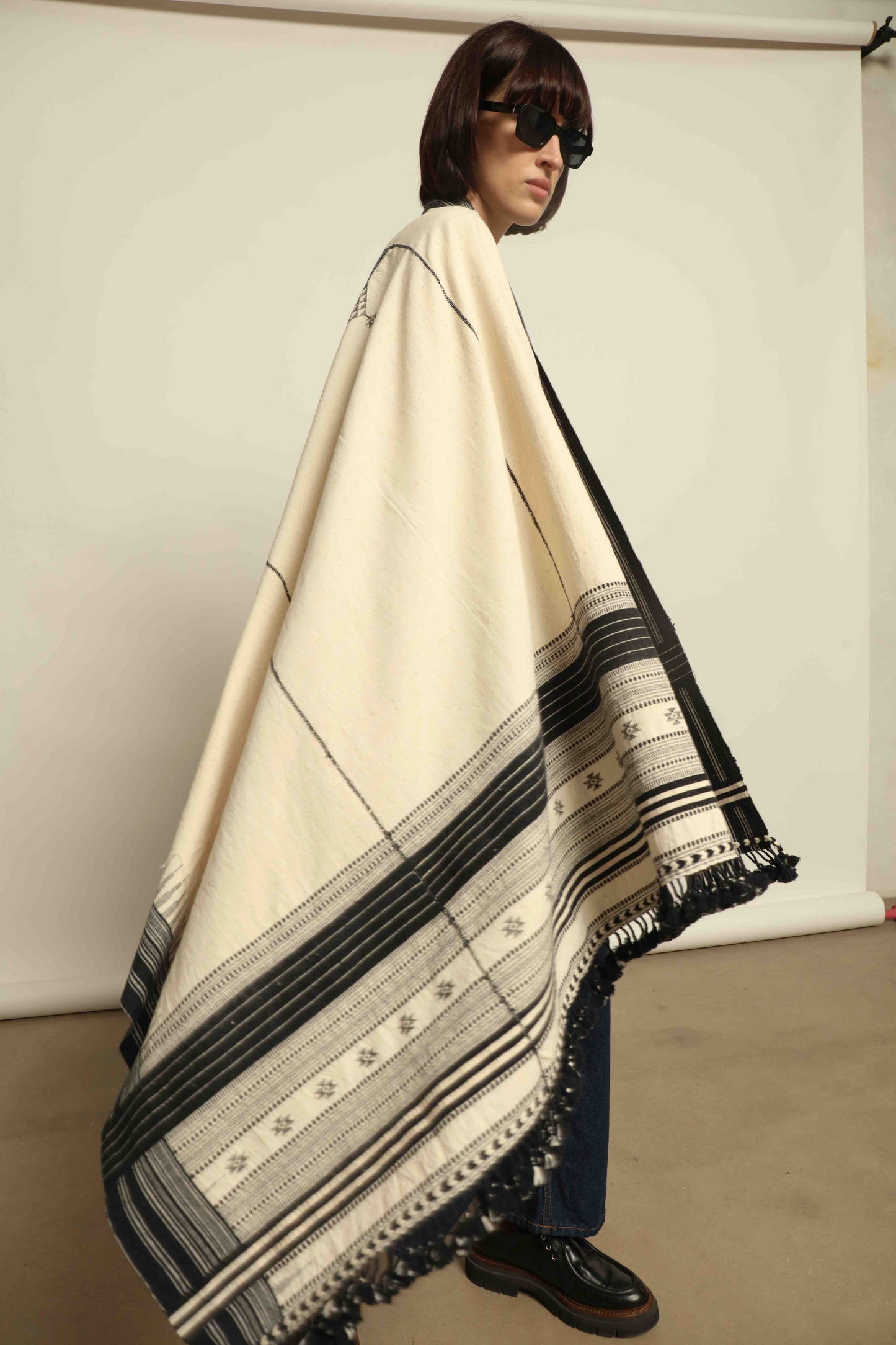Handwoven Kala cotton throw Ananta by House of Woven Stories, crafted with handspun yarn and embroidered panels by master weaver Shamji Vankar Vishram Valji in Bhujodi, India.