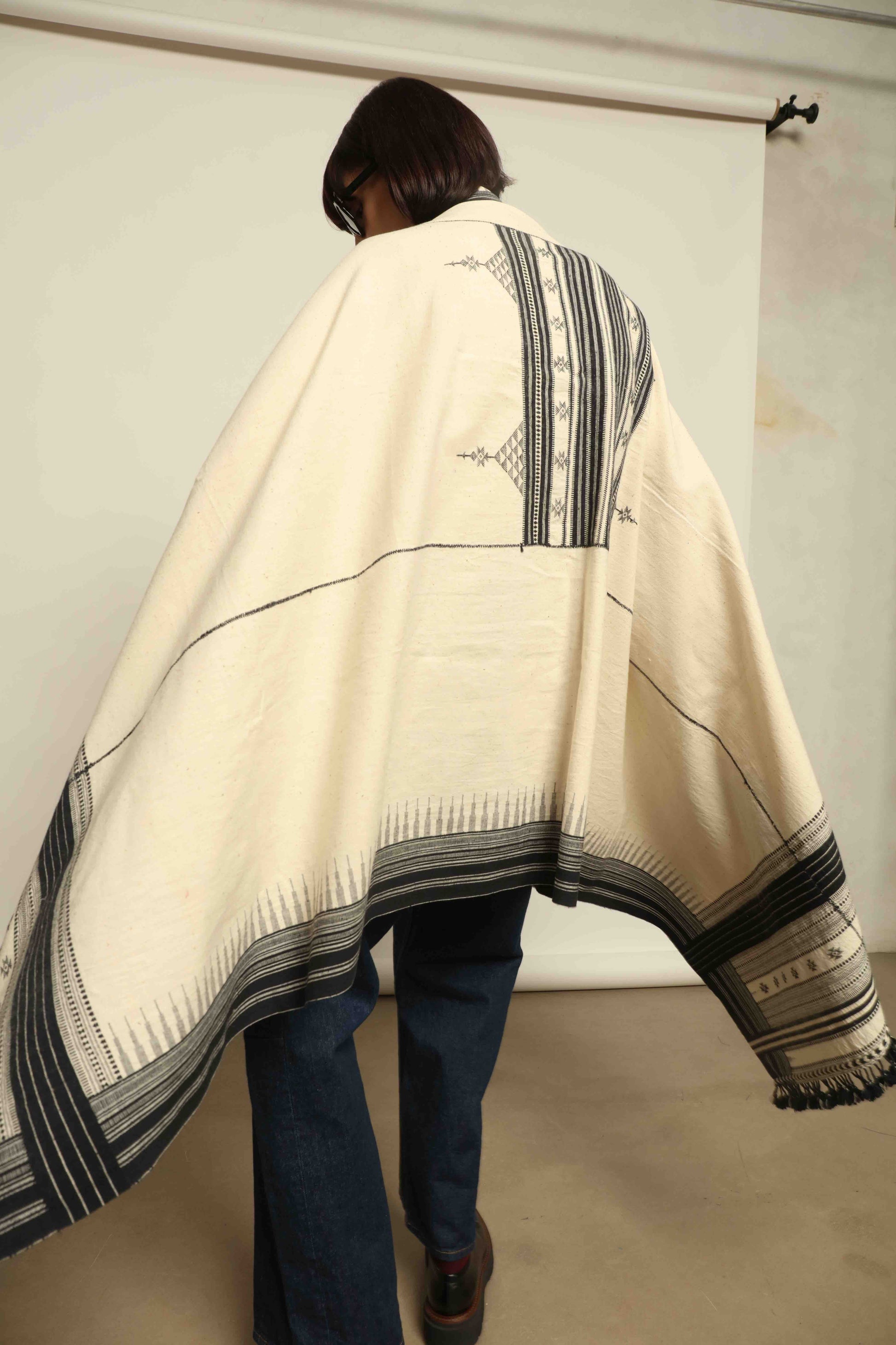 Handwoven Kala cotton throw Ananta by House of Woven Stories, crafted with handspun yarn and embroidered panels by master weaver Shamji Vankar Vishram Valji in Bhujodi, India.