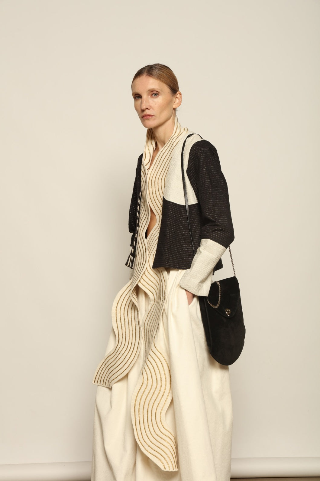 Model is wearing the Shory Gold Jacket by Ka-Sha, a handcrafted cotton jacket with black and white panels and fine gold stitching, curated in the House of Woven Stories selection.