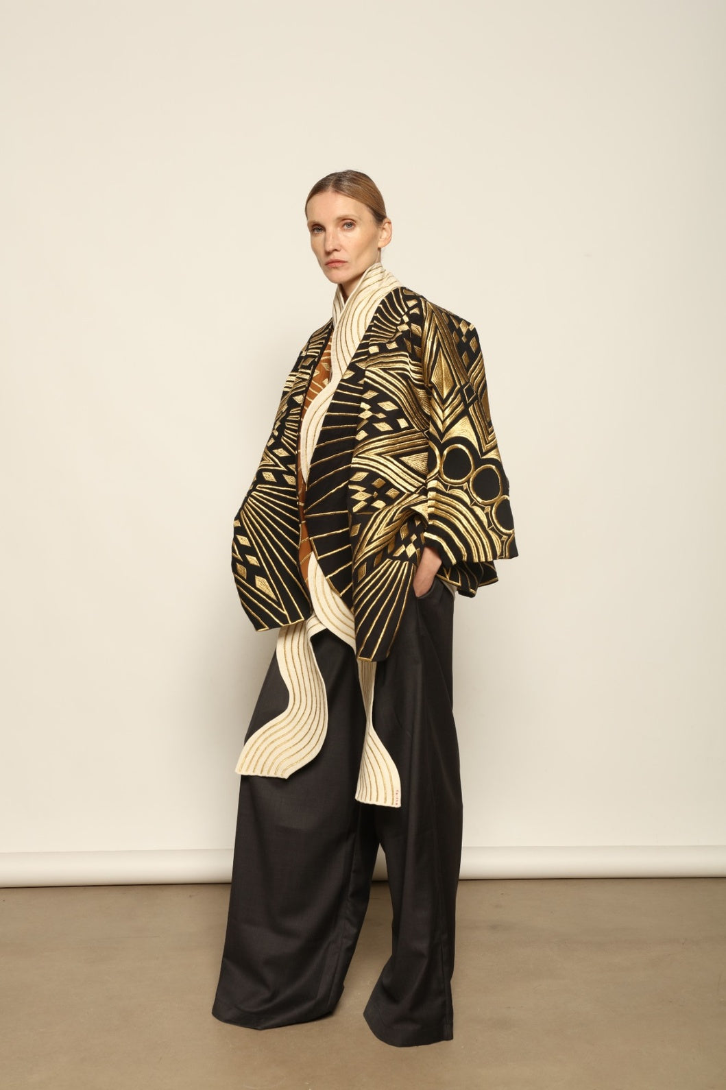 Model is wearing the Sunhera Reversible Jacket by Ka-Sha, a handcrafted cotton piece with rich gold stitching, offering two looks — black and gold or beige and gold — crafted over 65 hours and curated in the House of Woven Stories selection.