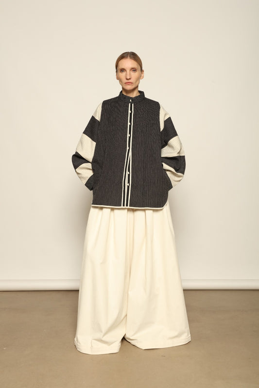 Model is wearing the Tri Bat Reversible Jacket by Ka-Sha, an artisanal reversible cotton jacket with bold black-and-white panels and wide sculptural sleeves, curated in the House of Woven Stories selection.