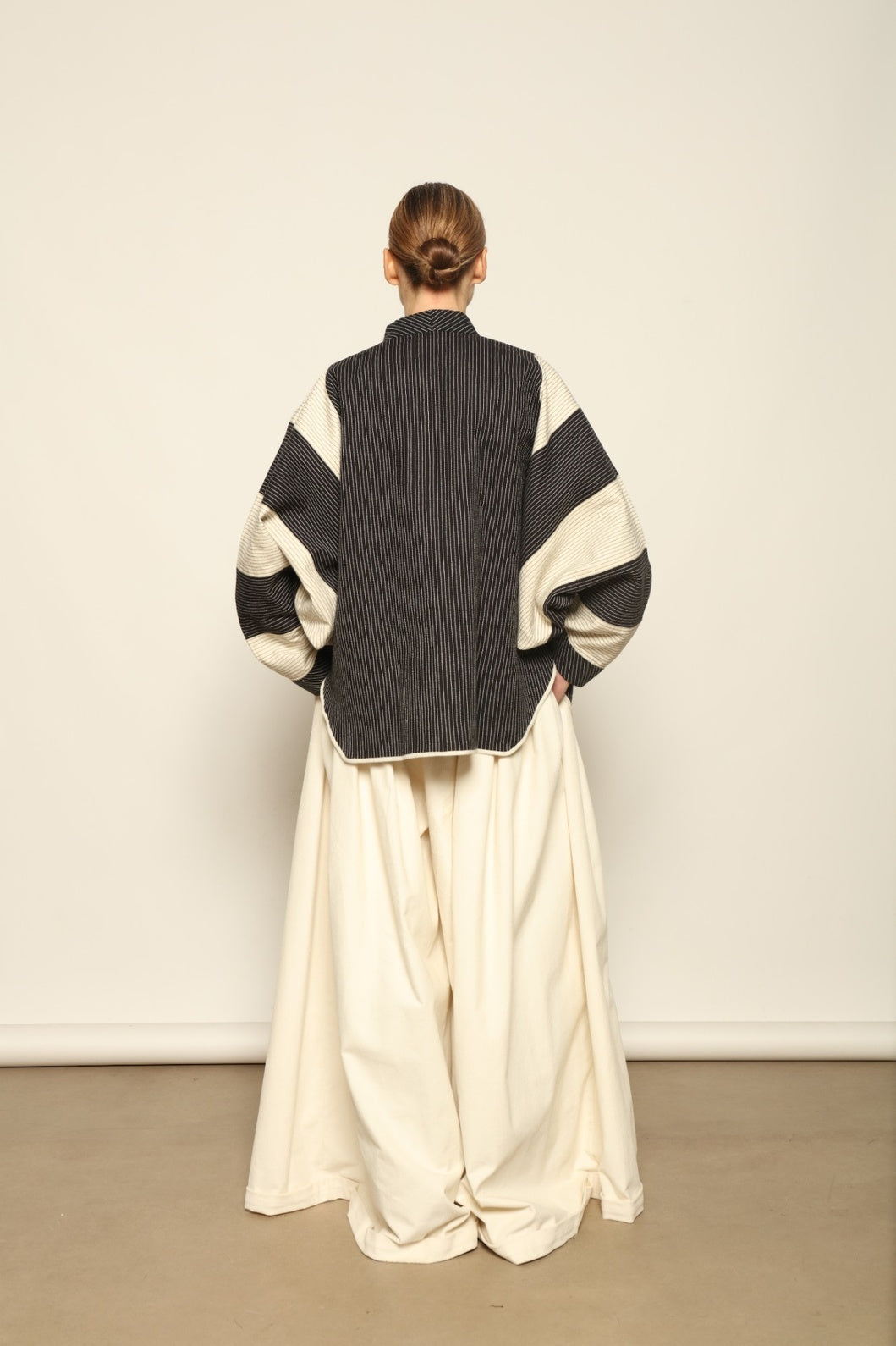 Model is wearing the Tri Bat Reversible Jacket by Ka-Sha, an artisanal reversible cotton jacket with bold black-and-white panels and wide sculptural sleeves, curated in the House of Woven Stories selection.