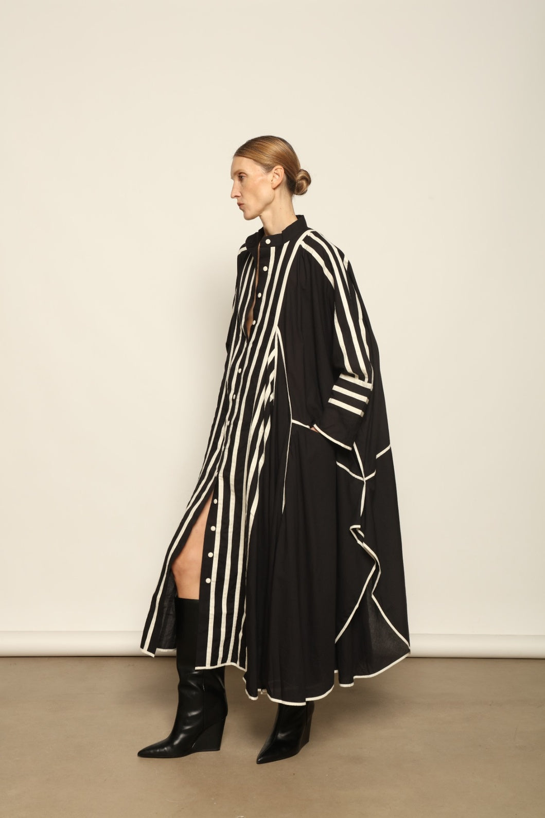 Model is wearing the Vibhor Tunic by Ka-Sha, a handcrafted black cotton tunic with off-white stripes, flowing sleeves and button-down front, curated in the House of Woven Stories selection.