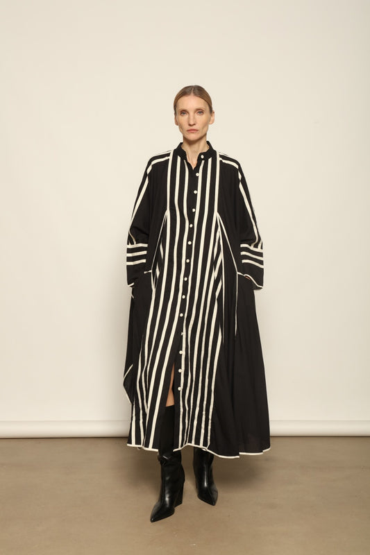 Model is wearing the Vibhor Tunic by Ka-Sha, a handcrafted black cotton tunic with off-white stripes, flowing sleeves and button-down front, curated in the House of Woven Stories selection.
