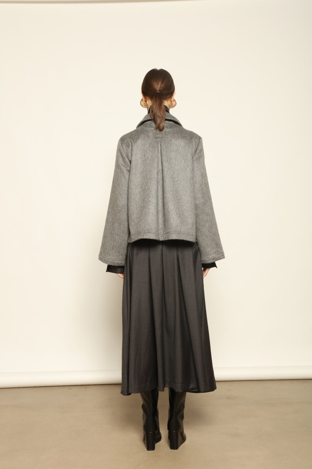 Model is wearing the Katharina Grey Pure Cashmere Wool Jacket by House of Woven Stories, crafted in Italy from upcycled cashmere wool with antique silk sari lining and vintage buttons.