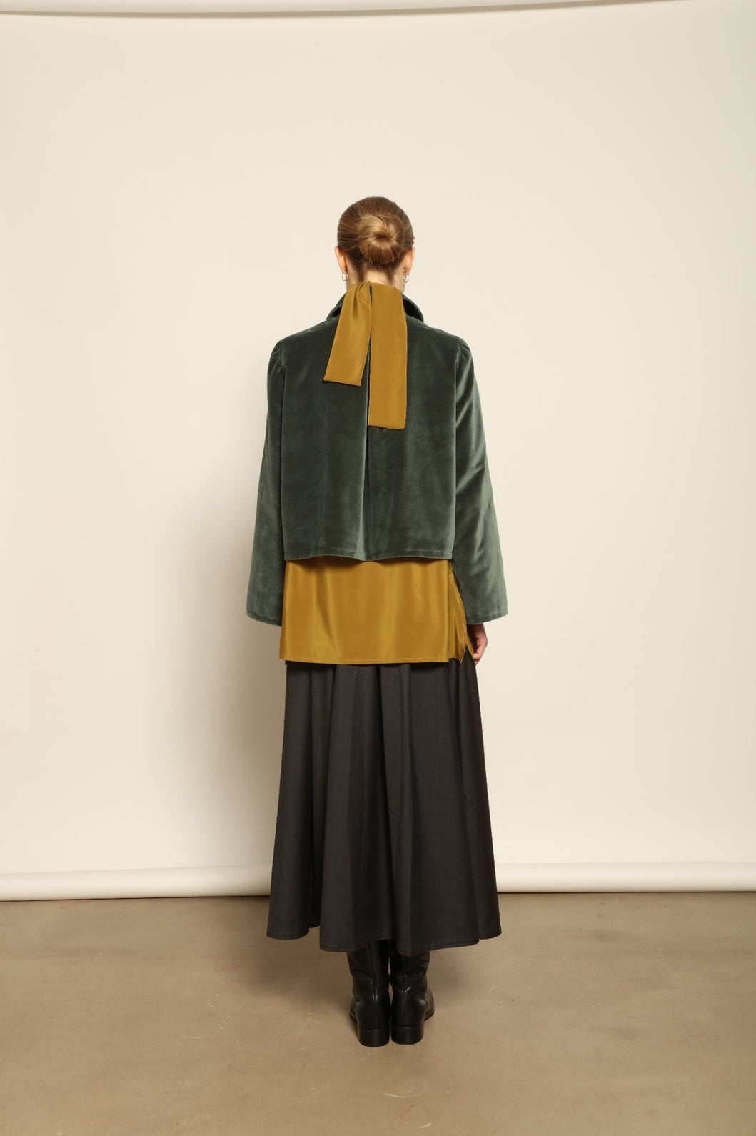 Model wearing Katharina Jacket in Velvet Green Cotton by House of Woven Stories, part of the curated selection, handcrafted in Italy from fine cotton velvet with hand-dyed shibori lining, expressing timeless elegance and artisanal craftsmanship.