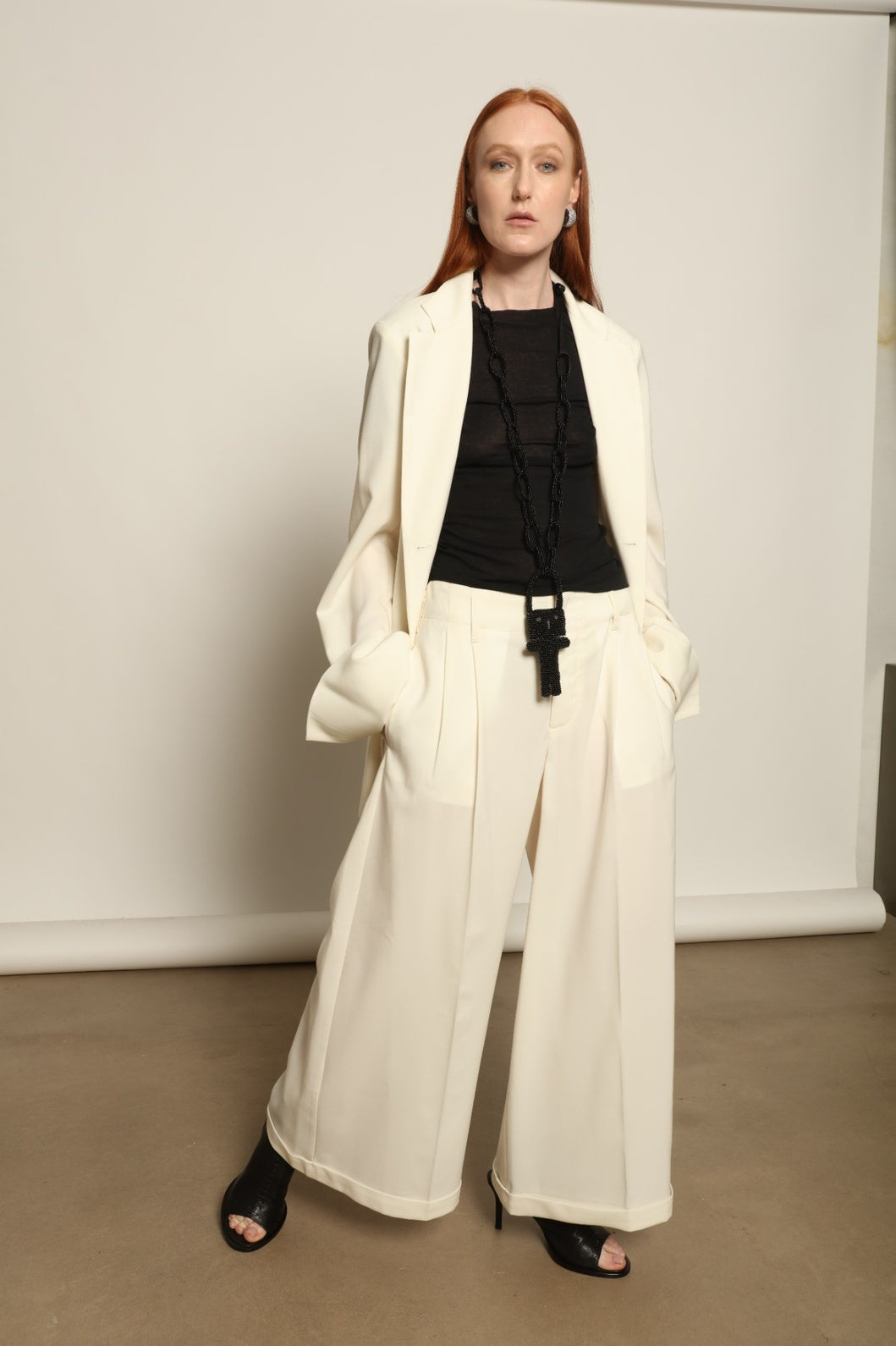Model is wearing the Katherine white cotton pant by Maison Jejia from the House of Woven Stories selection, featuring a fluid wide-leg silhouette crafted in Italy with refined tailoring and a clean, timeless design.