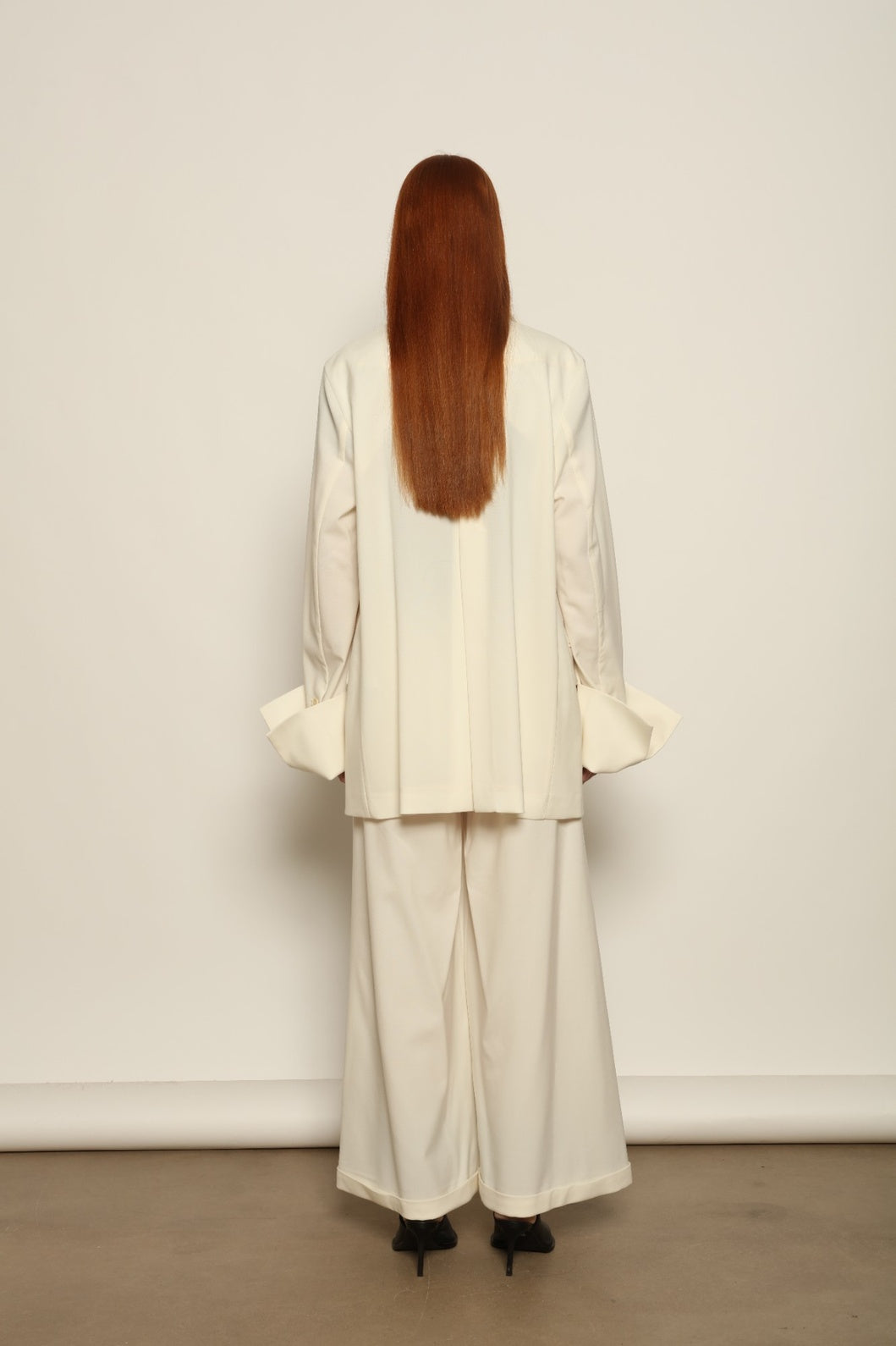 Model is wearing the Katherine white cotton pant by Maison Jejia from the House of Woven Stories selection, featuring a fluid wide-leg silhouette crafted in Italy with refined tailoring and a clean, timeless design.