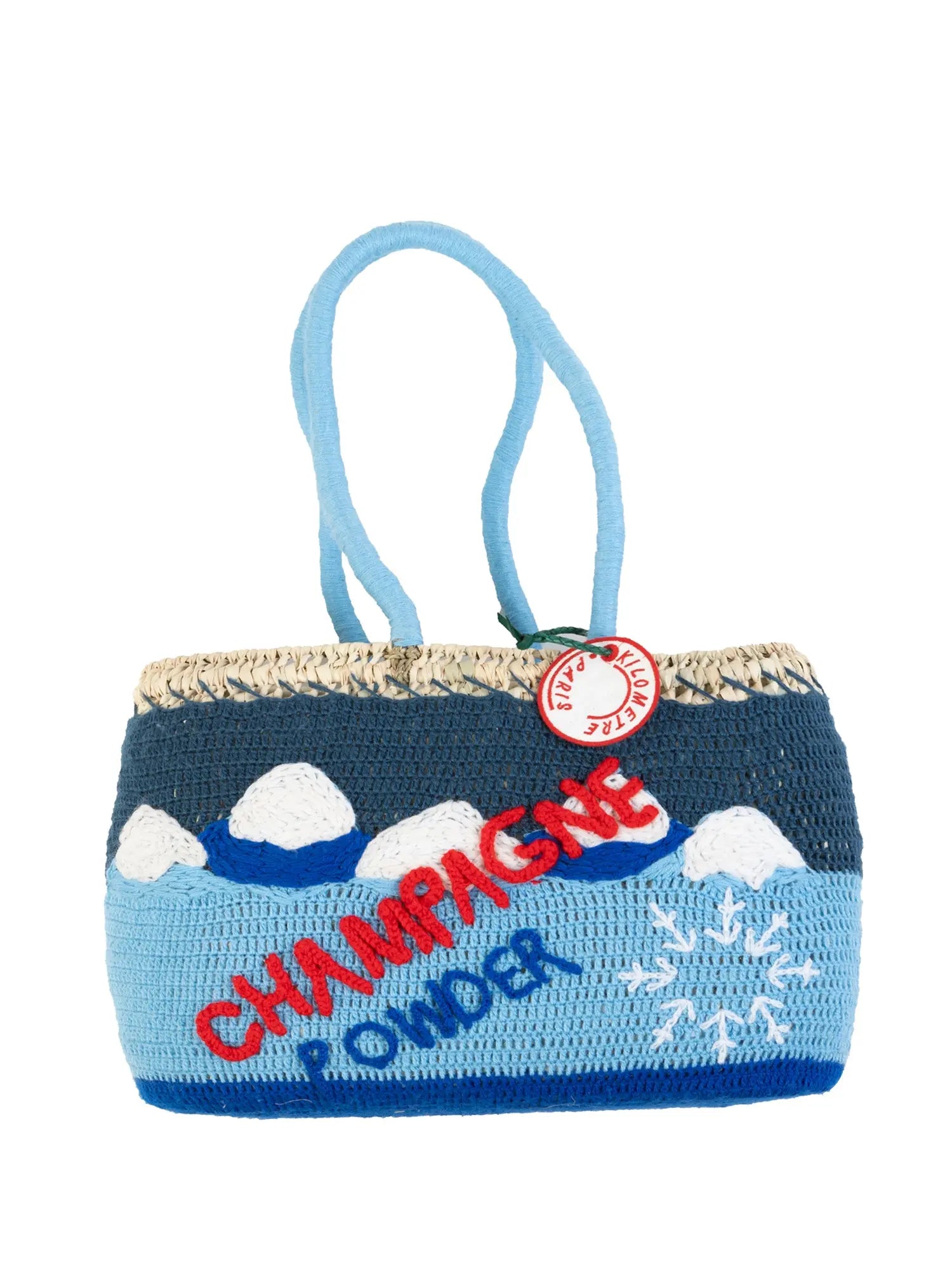 Undercover basket bag by Kilometre Paris inspired by winter exploration in Vail, Colorado, featuring embroidered mountain landscapes in blue and white on handwoven straw