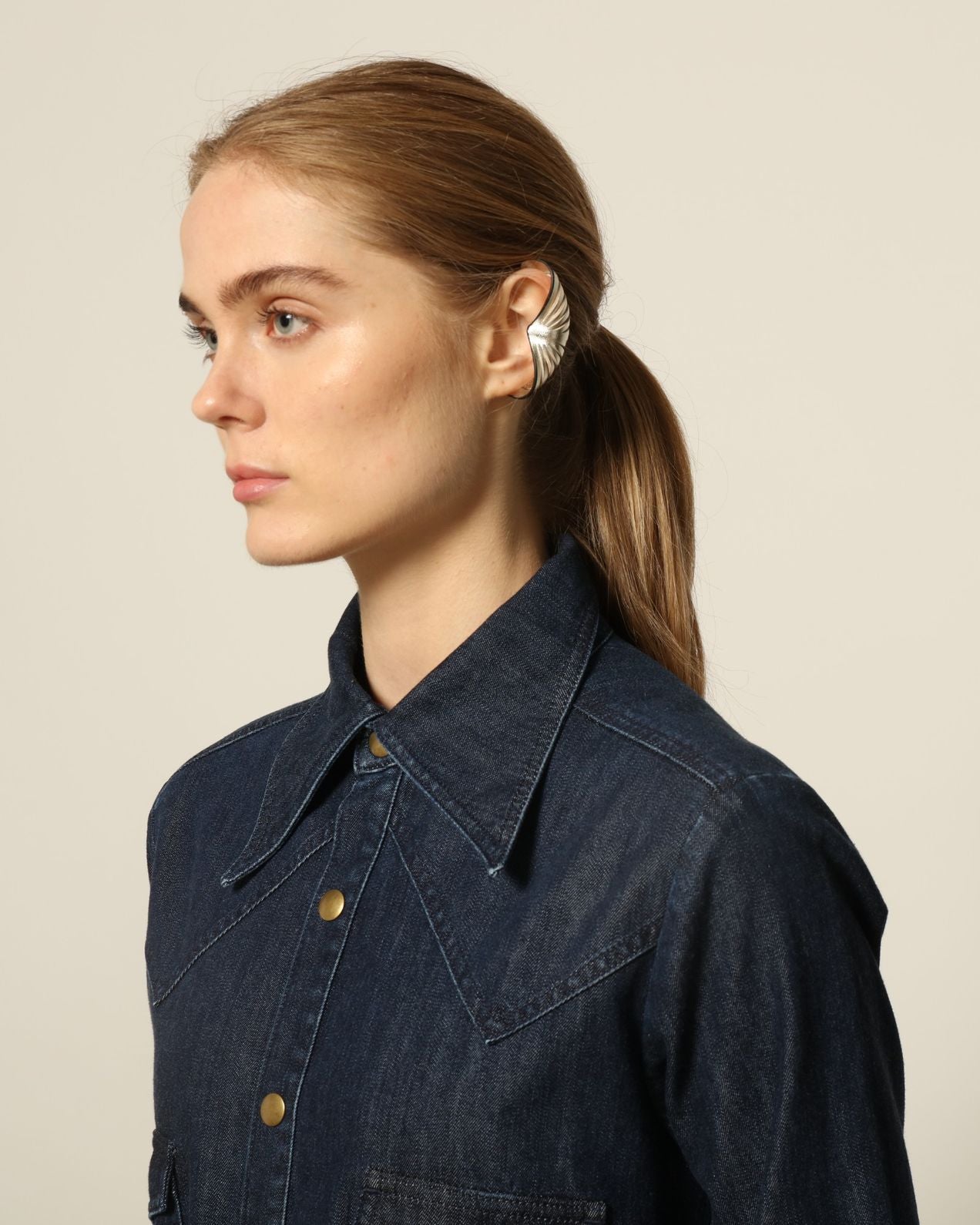Model is wearing La Robe Star in Bleu D’été by Happy Haus, a denim shirt dress with relaxed fit, chest pockets, matching belt, and golden button detail, combining timeless style with versatile year-round wear.